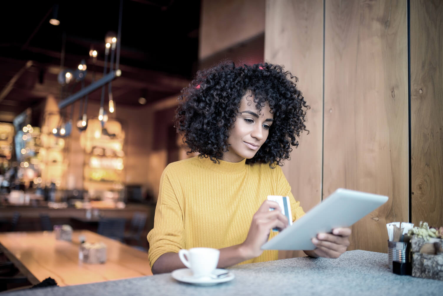 Young woman using a credit card with her tablet