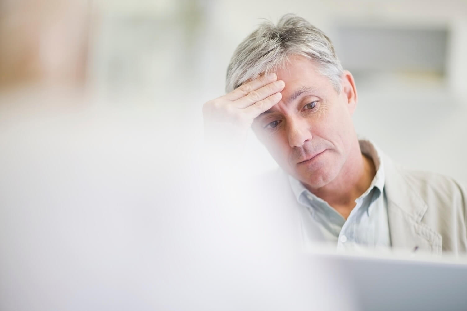 a man holding his head with his hand looking worried