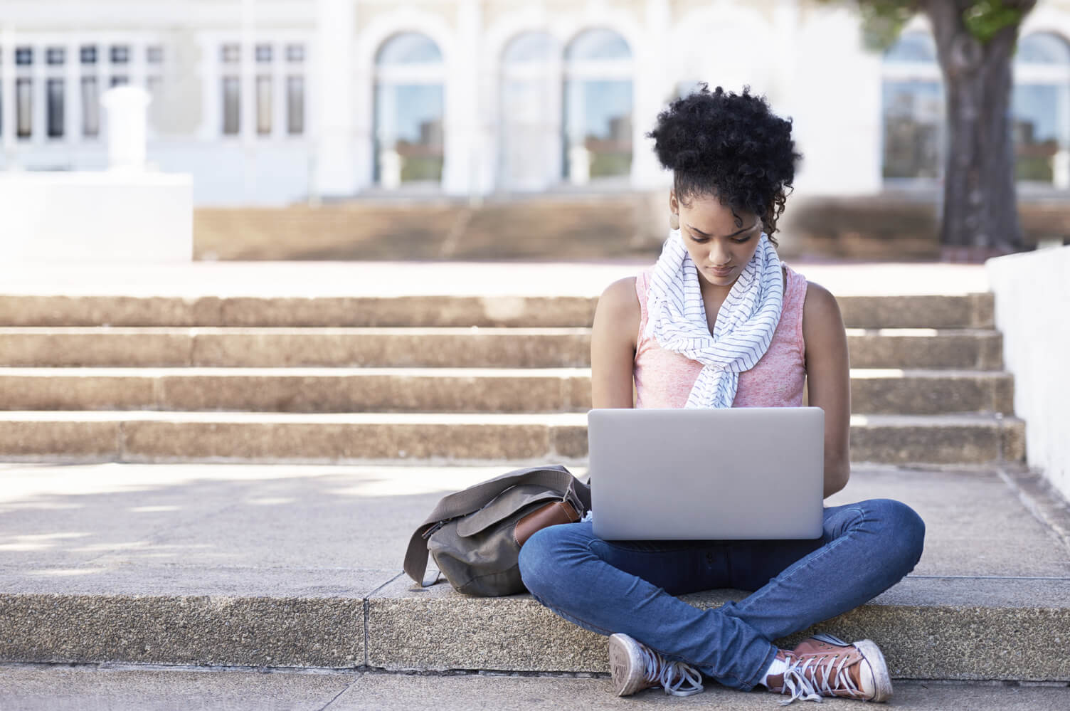 Young woman sitting outside using a laptop