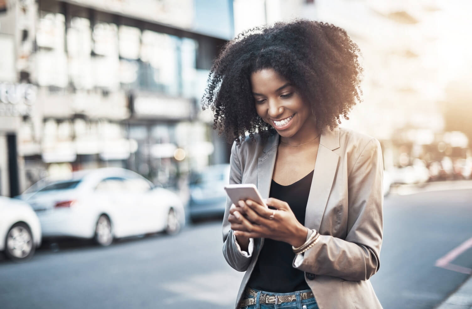 Woman walking along using her phone to apply for credit